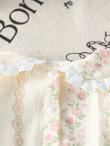 Detalle del cuello con encaje de ojalillo y broches del mameluco de rosas