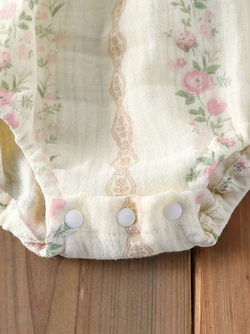 Broches en la entrepierna del mameluco de muselina con rosas