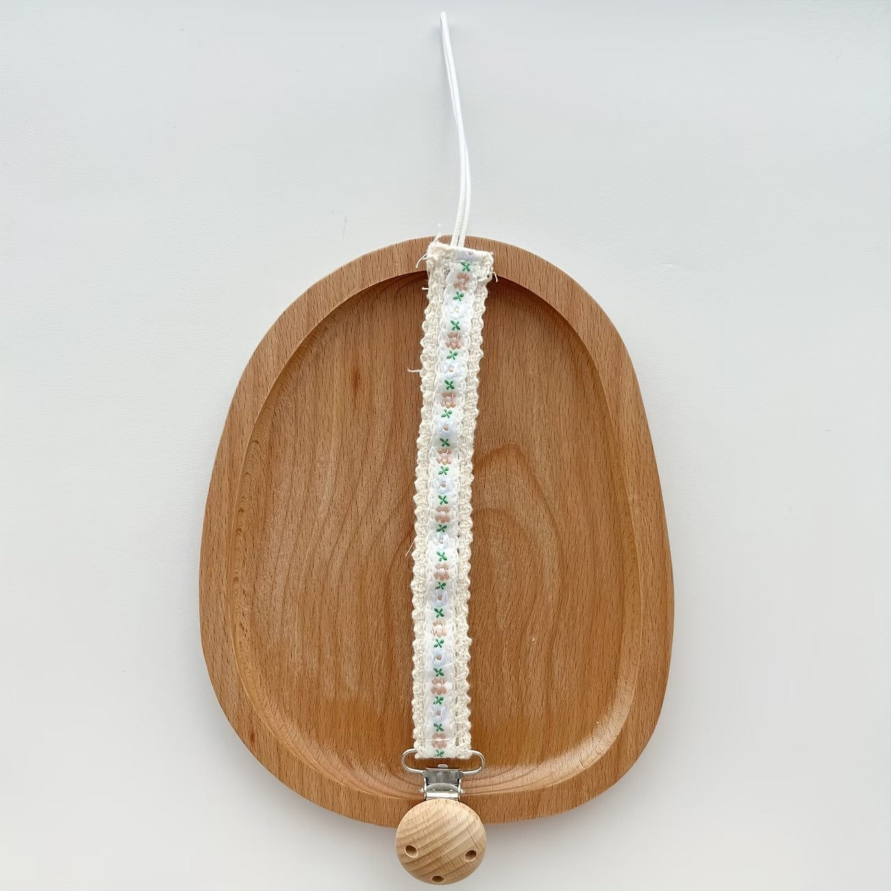 Portachupo de madera con cinta blanca, flores rosa y hojas verdes