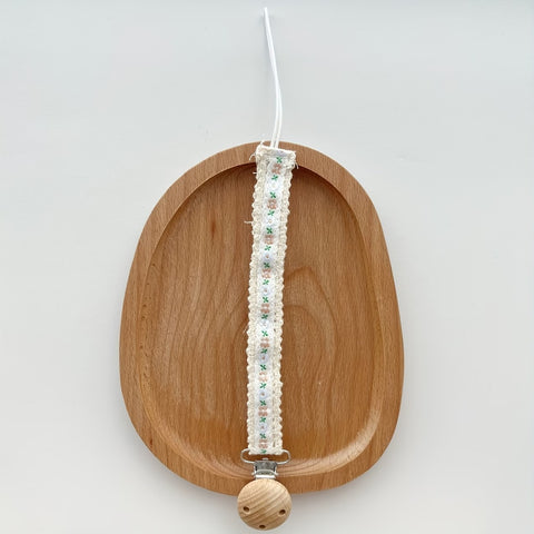 Portachupo de madera con cinta blanca, flores rosa y hojas verdes